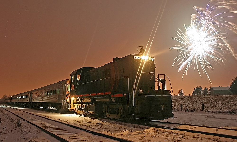 Judy's take of the Guelph Junction Express 2009/2010 New Year's Special with fireworks at Arkell. The combination of a slightly more head-on shot and a kit lens produced increased flare - normally not particularly desirable - but in this case I thought it added to the dramatic effects provided by the fireworks.