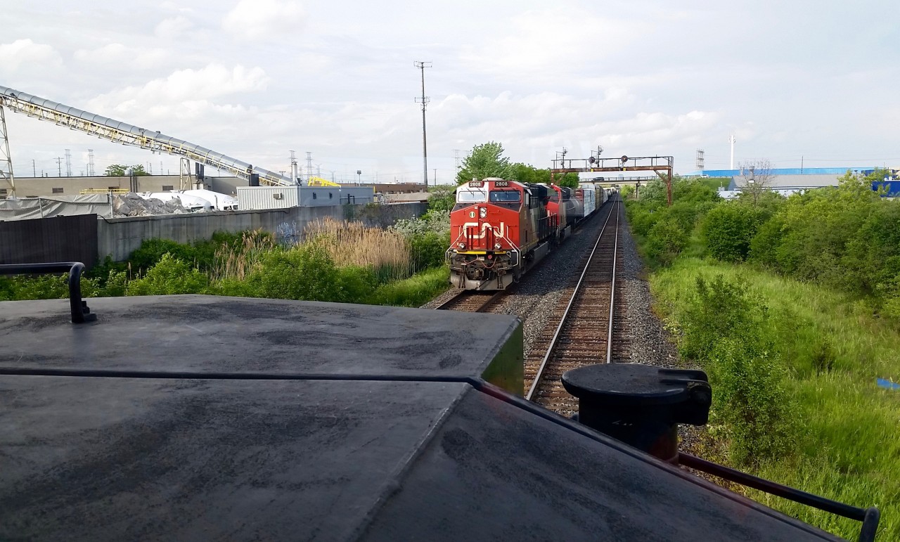 CN 383 has just left Mac Yard and crossed the Humber River on its way to Sarnia, Ont. Lead by ES44AC 2808 an unknown sister trailing and ET44AC 3003 in DP mode mid train.

 CN L570 waits for 383's tail end to clear Humber. The "WisperCab" split on CN SD70-2M  8964 can be seen through the window on this shot.