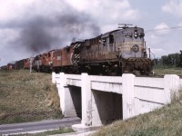 Pulling hard toward Farnham QC an eastbound frieght with five MLW units crosses Autoroute 15 between Delson and Desnoyers.  The train has an RS-18, FB-2, RS10, RS-3, RS-10 power consist typical of Adirondack sub trains at the time.

