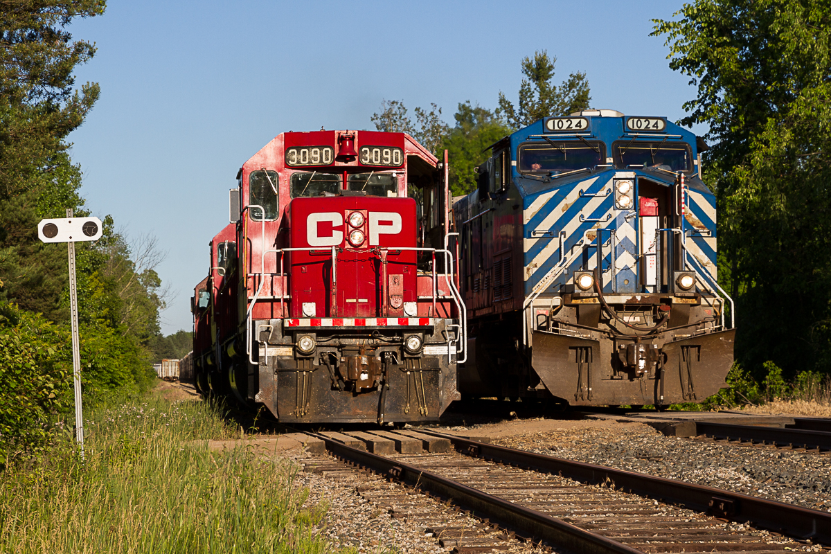 A Rare Meet at Waterdown North! I've always found something really intriguing about obscure industries and seldom used trackage. One such example is the Barnes industrial complex at the top of the Waterdown hill. Now operating under the Opta Minerals banner, this facility produces BriteSphere Reflectorizing Glass Beads and receives infrequent rail service from CP's Hamilton yard jobs. Much of the infrastructure here dates back to the early days of the Hamilton (nee Goderich) Subdivision, with stick rail and the old Waterdown North Station still in place. When I moved into the area 8 years ago, this location is one that I would visit from time to time in hopes of catching a train working the industry. Alas, that never happened. Once in a blue moon CP would stage a meet here but they were few and far between. Today, I finally got, not only a train on the spur track, but a meet! Here, a trio of GP38-2s are tied down in the siding as CEFX 1024 sneaks by with train no. 255. The GPs were assigned to evening pusher duties when RTC instructed them to meet 255 at Waterdown North before heading back south. A friendly crew, some nice power and golden evening light made for a very memorable photograph. For all I know, this may be the only photo ever taken of a meet here. If anyone happens to know of any other photos from this location I would love to see them!