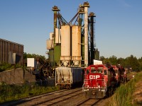 A trio of EMD GP38-2s trundle by the Barnes industrial complex after pushing 142 up the hill and meeting 255 at Waterdown North. Now operating under the Opta Minerals banner, this facility produces BriteSphere Reflectorizing Glass Beads and receives infrequent rail service from CP's Hamilton yard jobs. Much of the infrastructure here dates back to the early days of the Goderich Subdivision, with stick rail and the old Waterdown North Station (visible far right of frame) still in place. This sprawling complex is the only major industry in Waterdown served by rail and is very seldom photographed.