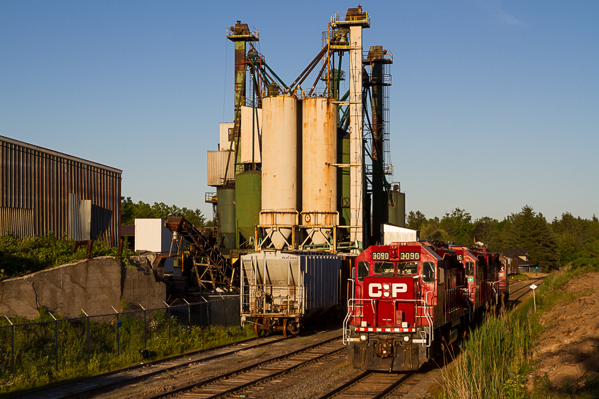 A trio of EMD GP38-2s trundle by the Barnes industrial complex after pushing 142 up the hill and meeting 255 at Waterdown North. Now operating under the Opta Minerals banner, this facility produces BriteSphere Reflectorizing Glass Beads and receives infrequent rail service from CP's Hamilton yard jobs. Much of the infrastructure here dates back to the early days of the Goderich Subdivision, with stick rail and the old Waterdown North Station (visible far right of frame) still in place. This sprawling complex is the only major industry in Waterdown served by rail and is very seldom photographed.
