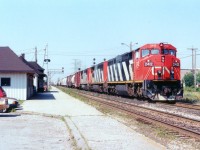 With a potential 12000 HP up front, a trio of nearly new Dash 8s are seen heading east on the Oakville  Sub rather than going up the Halton,  a rather uncommon practice in todays world. CN 2412, 2401 and 2425 provide the power. On the left, the old buildings are gone, the closest demolished and the other is CN Burlington West, since relocated, preserved, fronting nearby Fairview Av.