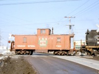 Canadian National wooden centre cupola caboose 77831 (not matching the typical CN offset-cupola appearance, as it was one of the few GTW cabeese transferred to CN) trails a CN S13 switcher across Kipling Avenue crossing in Rexdale, on the Brampton (soon to be Weston) Subdivision in 1963.
<br><br>
This crossing has since been grade separated in 1968, and just a stone's throw away is the site of the present-day Etobicoke North GO station. While Metrolinx currently owns the Weston Sub, CN locals continue to service the remaining industries (albeit, without a caboose).