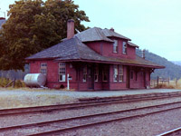 I was driving back to Vancouver BC on highway 3 when I spotted some CP buildings on the north side of the road at Midway BC. I pulled over, & walked around yards for a few minutes & there was no railway activity  at all. No rolling stock, just a soft wind. I took what pictures I could until I ran out of film. While there I took two pictures of the station. The attached picture turned the best. The other one taught me not to keep the camera strap too close to the lens. The hills in the background are in the USA. I'm glad the town kept the station, & used it to promote the local history.