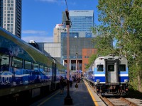 <b>The evening rush hour.</b> Two Candiac-line trains are at Lucien L'Allier station in downtown Montreal during the evening rush hour. Behind is the Bell Centre and the new Deloitte tower.