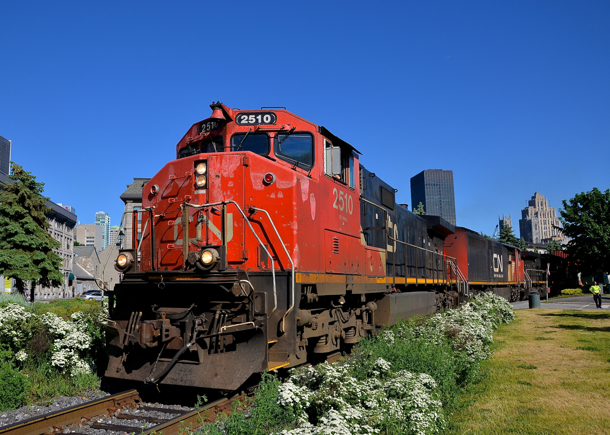 A Dash9-44CWL leader. In faded paint, veteran Dash9-44CWL CN 2510 leads CN 149 out of the Port of Montreal. The third unit is another Dash9-44CWL (CN 2520), with an even older GE (Dash8-40CM CN 2429) in second position.