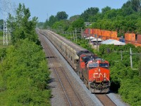 <b>A potash train snaking its way eastwards.</b> Potash train CN B730 has 151 loads destined for New Brunswick as it snakes through a sag on CN's Kingston sub in Pointe-Claire. Heading east at the same time at right is CP 118 on CP's parallel Vaudreuil Sub. Power on B730 is 4 DC units: CN 2310 and CN 8009 at the head end, with CN 5667 & CN 8946 shoving at the rear.