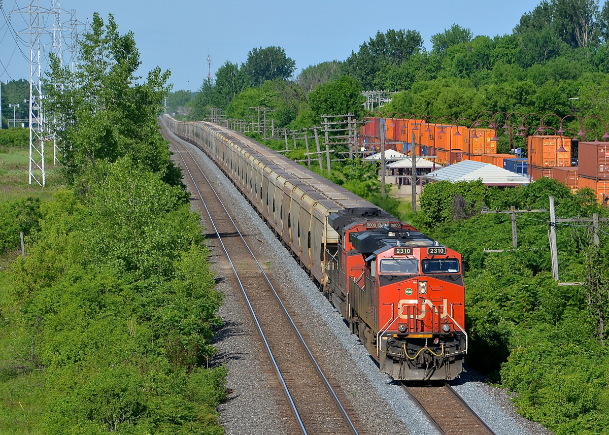A potash train snaking its way eastwards. Potash train CN B730 has 151 loads destined for New Brunswick as it snakes through a sag on CN's Kingston sub in Pointe-Claire. Heading east at the same time at right is CP 118 on CP's parallel Vaudreuil Sub. Power on B730 is 4 DC units: CN 2310 and CN 8009 at the head end, with CN 5667 & CN 8946 shoving at the rear.