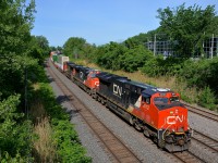 <b>3 GE models at the head end, a fourth mid-train.</b> CN 120 is eastbound on the Montreal Sub with 4 GE units, all different models. Up front is ET44AC CN 3012, ES44DC CN 2230, Dash9-44CW CN 2663, with ES44AC CN 2887 mid-train. This long train bound for Halifax is 624 axles long.