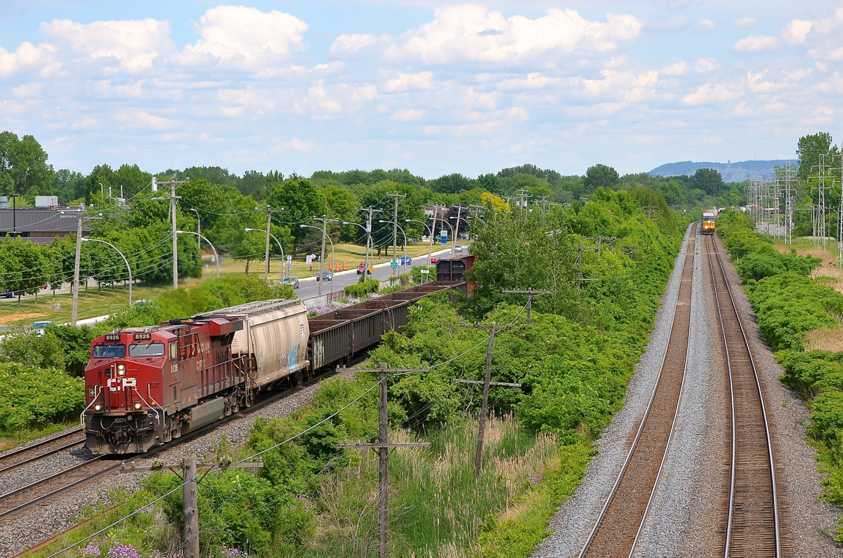 CP 119 in the lead. Based on scanner chatter, I could hear that both CP 119 and CN 327 were headed my way and I was not quite sure which would show up first.... Well CP 119 showed up first (barely), with CP 8926 as the sole head end power, with another ES44AC as mid-train DPU (ironically, CP 8925). CN 327 is close behind, his headlight is visible at far right on CN's Kingston sub.