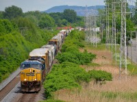 <b>Mount-Royal in the distance.</b> CN 327 is westbound through Pointe-Claire led by big GE product CSXT 631, an AC6000CW. In North America only CSXT and Union Pacific bought these units, and in limited numbers. Trailing is an ex-Seaboard SD50 (CSXT 8613). In the distance is Mount-Royal.