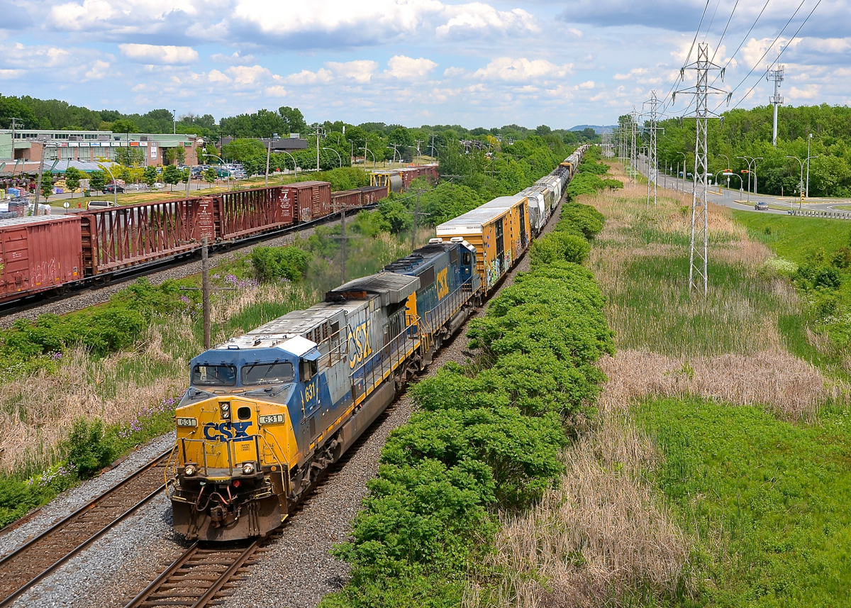 A (somewhat) rare GE model leading. CN 327 is westbound through Pointe-Claire led by big GE product CSXT 631, an AC6000CW. In North America only CSXT and Union Pacific bought these units, and in limited numbers. Trailing is an ex-Seaboard SD50. At left is CP 119 on CP's parallel Vaudreuil sub, its head end had passed just 30 seconds before CN 327's did.