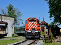 <b>Stopped in front of Barrington Station.</b> Exporail's Sunday-only excursion train is seen in front of Barrington station after its last run of the day. GP9 CP 1608 leads passenger car CN 5064 and at left is small portion of narrow gauge car CN 760 (used in Newfoundland); both of the passenger cars were built by Canadian Car & Foundry in Montreal. At right is a staircase that is used to load the wood at right into the <i>John Molson</i> steam engine.