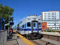 <b>Past the 'superhospital'.</b> Cab car AMT 2002 leads AMT 187 (bound for Saint-Jérôme) towards its first stop at Vendôme Station. To the right of the train is the recently opened McGill University Health Centre, dubbed the superhospital locally. It was built on the site of CP's Glen Yard.