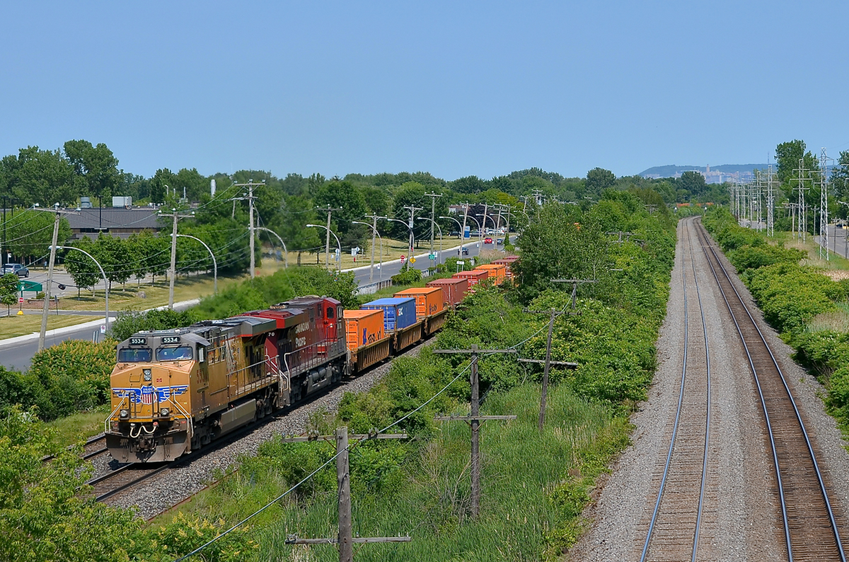 A UP leader on CP. UP 5534 and CP 8870 lead CP 143 west through Pointe-Claire on the south track of the CP Vaudreuil Sub. At right is the CN Kingston sub; both main lines parallel each other for many miles in Montreal and just west of it.