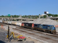 <b>A blue devil by the daylighted tunnel.</b> CN 323 is returning from St. Albans, Vermont with 'blue devil' IC 2457 leading and SD75I CN 5719 trailing. It is passing the site of the Turcot West tunnel which was daylighted a few weeks ago.