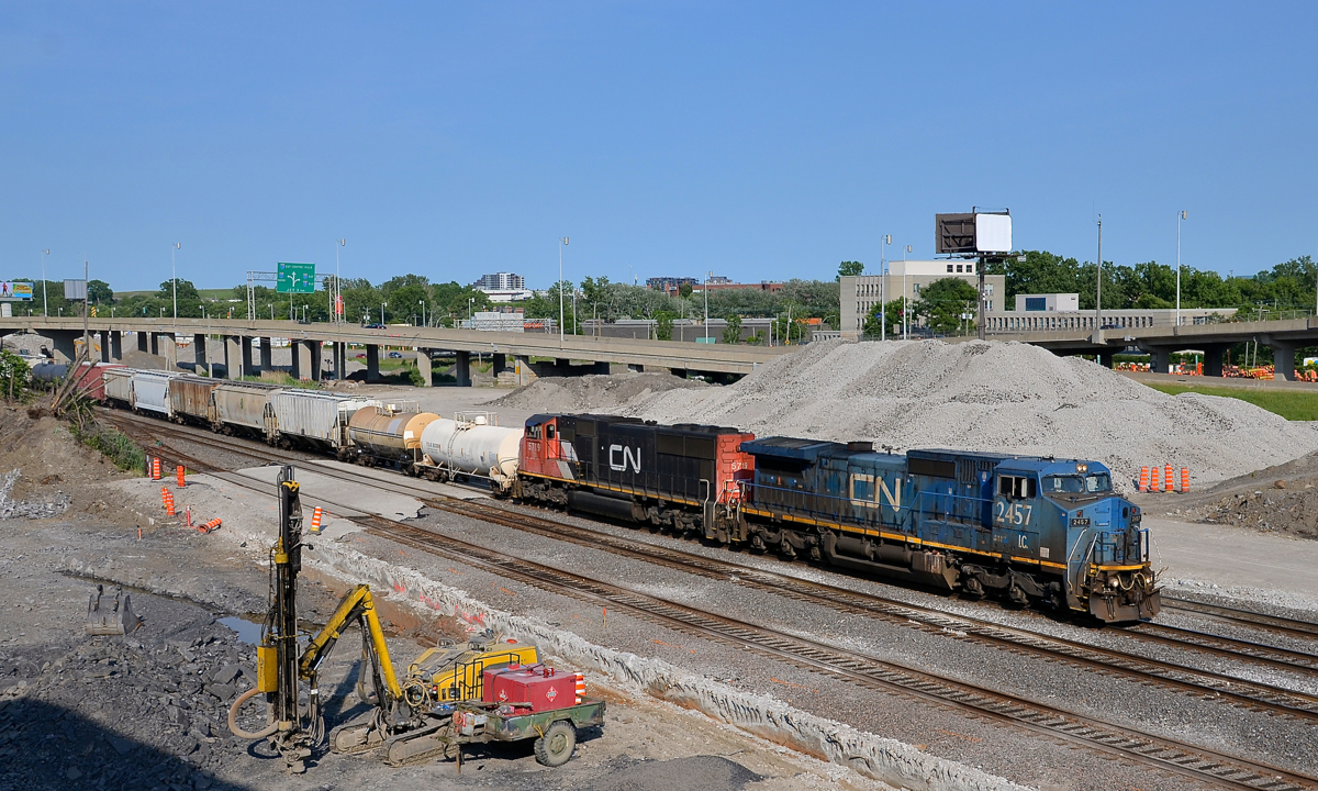 A blue devil by the daylighted tunnel. CN 323 is returning from St. Albans, Vermont with 'blue devil' IC 2457 leading and SD75I CN 5719 trailing. It is passing the site of the Turcot West tunnel which was daylighted a few weeks ago.