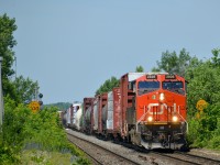 CN 2826 leads CN 368 past the speed limit signs at Dorval, which are partially obscured by growth. Operating mid-train is CN 2857.