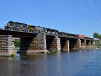 <b>A SpongeBob and a big AC6000CW.</b> 'SpongeBob SquareCab' SD40-3 CSXT 4071 and AC6000CW CSXT 675 lead a short CN 327 (43 cars) over the Ottawa River on a scorching day.