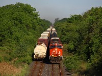 Lately, CN 421 and 422 have been operating at pretty consistent times, and regularly meet between St. Catharines station and around Garner Road in Niagara Falls. In which case, they rarely delay each other since that is a double track section, and I'm guessing it is planned that way by the crews and the RTC. Nonetheless, CN 421 was running later than normal, and 422 also showed up a little later than normal. That still wasn't enough to prevent a sitting meet for 422. Even with only one eastbound and westbound daily scheduled freights and 33/43 miles of the Grimsby Sub being double track, the chances are still there. Seen here, CN 421 charges into the bottom of the Jordan dip with its usual lengthy train in tow as 422 waits for it to clear the Jordan interlocking. So was 422 long? By today's standards, no, which is unusual, especially now that 330/331 are gone and the as required 523-4/562 trains have not been running much with the regular summer traffic downturn. 106 cars that is, and CN 3060 doing a one unit wonder. If I can recall the last time I saw 422 with one unit, I believe that was the summer of 2009, when it was still a medium sized train. It was clear there was a lack of autoracks and other mixed freight (besides 331's tankers) on this 422, so it must have been one of those really slow days. It does seem car counts are diminishing again though, even for summer standards, as 421 and 422 on some days (even when 523 and 524 are not running) show no improved length since 330/331 were cancelled. On a lighter note, 422 was around 180 cars the next day, so some traffic must have just gotten held up from the previous day.