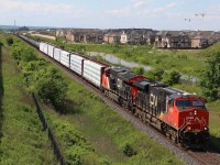 CN train 435 has a GE built ES and T4 in charge of the days train to London. Urban sprawl is taking over here in Milton with new residential developments popping up all across the town. The tall cranes in the background mark the site of the expanding hospital, and the Niagara escarpment can be seen in the distance. 