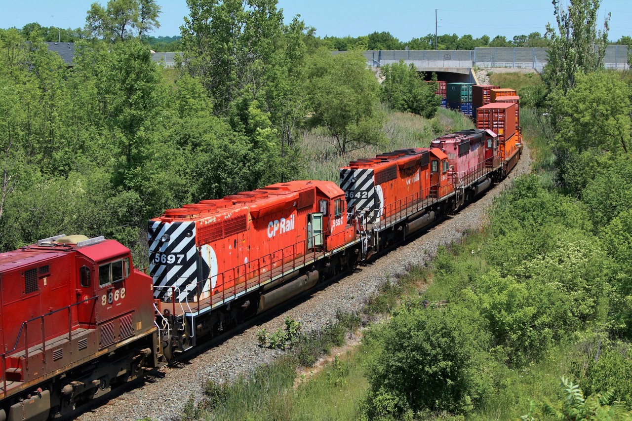 CP train 246 had these three SD40-2 engines tucked in on their last ride to Larry's Trucking for scrap. CP 5697, CP 5642, and STL&H 5560 round the bend under the Highway 6 overpass on their way for a stop at Kinnear. I guess they left the door open on CP 5697 for the ghosts of the past to exit at their convenience.