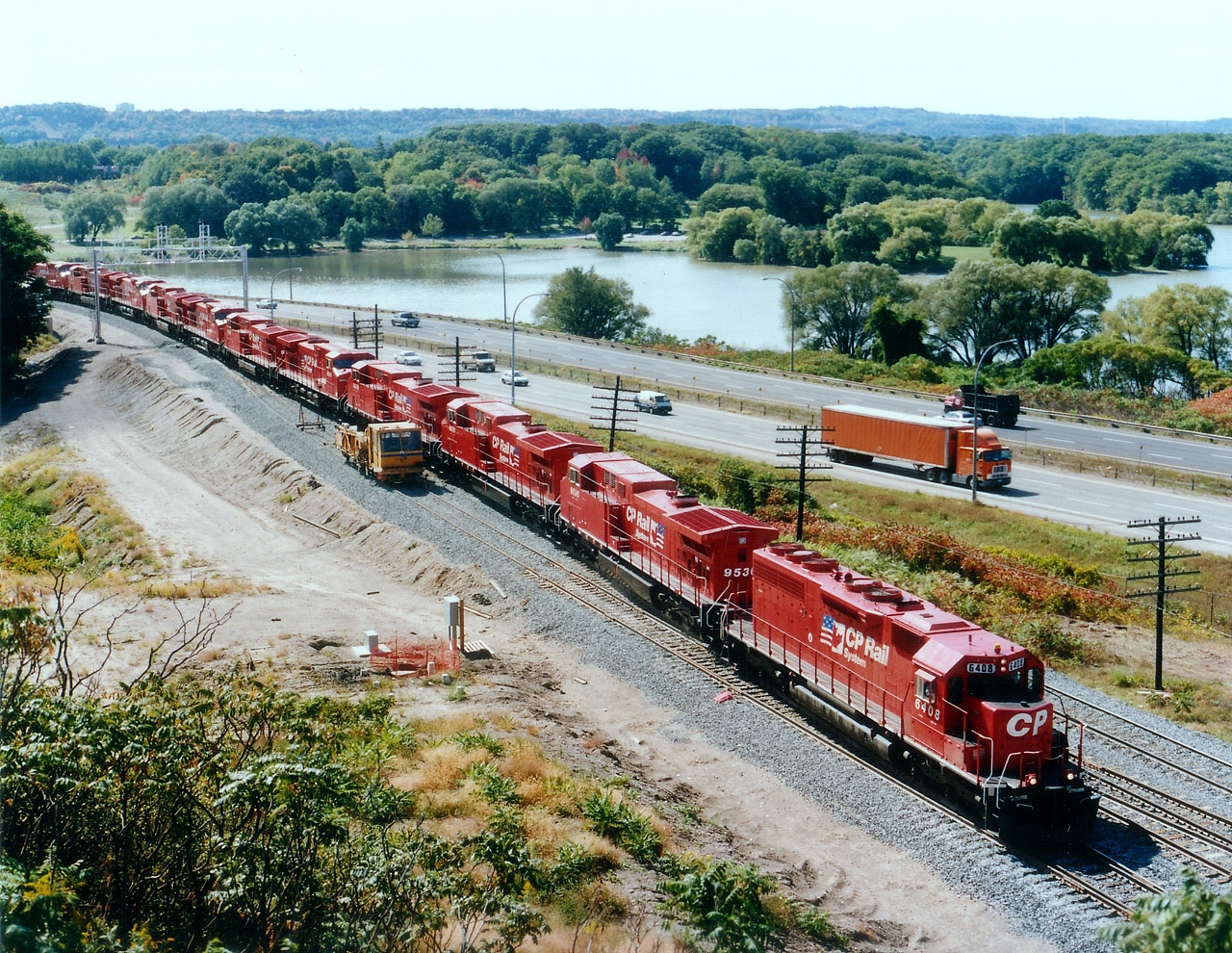 Us lads trackside certainly did a lot of whining over ugly, grubby CP locomotives on the lead of many trains this past couple of years, their very presence often ruining the overall classy photo we hoped to capture. Now, suddenly, I notice they have vanished.  Apparently most all the 9500 series (AC4400CW)units have gone into storage due to a downturn of traffic. So the opportunity to dig up a photo of back when these were new out of Erie PA, a scant 21 years ago, presents itself.  Here is train #521 (USA to Toronto) as seen from beside the High Level bridge in Hamilton. For viewers out of province, that is Hwy 403 in background, very quiet looking compared to todays' crush of traffic; and beyond that, Cootes Paradise, a quiet mostly severed (from Hamilton Harbour) protected body of water. Locos that can be seen: CP 6408, 9536, 9531, 9539, 9529, 9528, 9538, 9544, 9545, 9547, 9542 and 9541. The units looked nice when new..but that didn't last. I'm glad CP has since gone back to a better quality of paint.