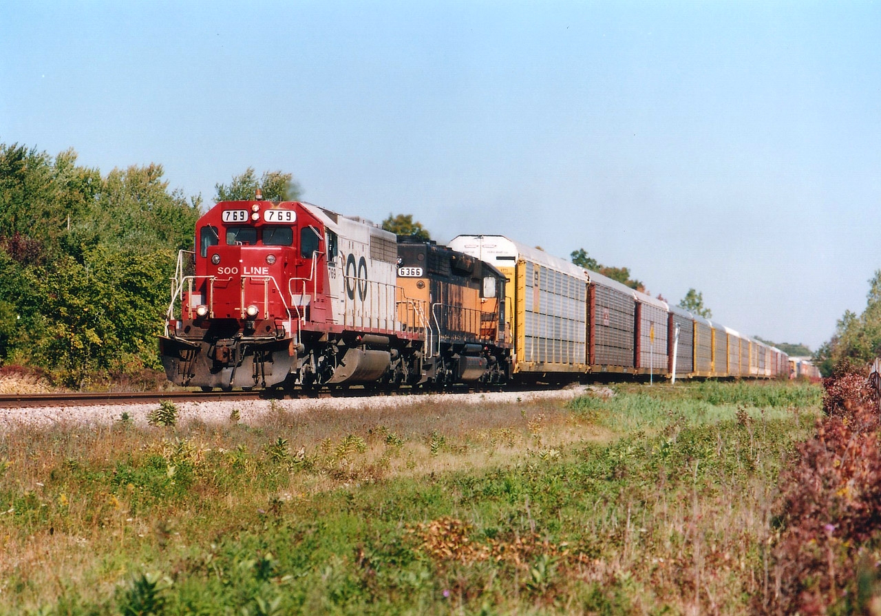 From the USA, closing in on Brookfield, is CP's #523 running on the old line that once crossed thru Clifton Hill, the NF tourist mecca. Train tie-ups aggravated the daylights out of everybody there until the city of Niagara Falls was able to rid themselves of this railroad around 15 years back. On this pleasant fall day we see SOO 769, and HLCX 6366 crossing the country lane of Yocum Rd. The 6366 was a former MILW, now part of the fleet leased by CP which totaled around 200 units at this time. Amazing variety. But how times have changed. Currently CP has over 650 of their own units in storage around the country.