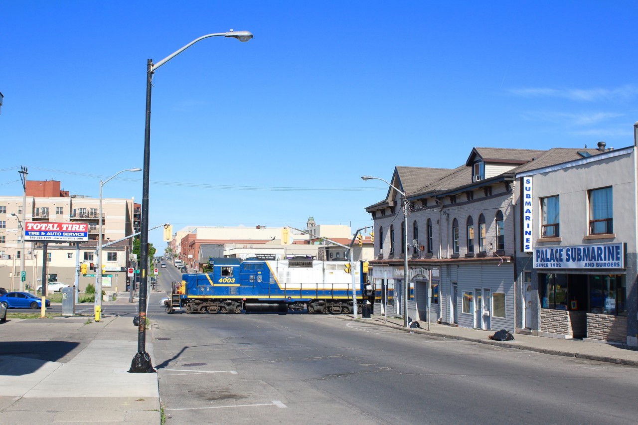 The once a week SOR job that serves to last surviving customer on the Burford spur has just set off the traffic lights at the corner of Colborne and Clarence Street and are rolling past the old downtown in Brantford, on their way to the former TH&B trackage. GP9 4003 has become a regular for this job based out of Hamilton.