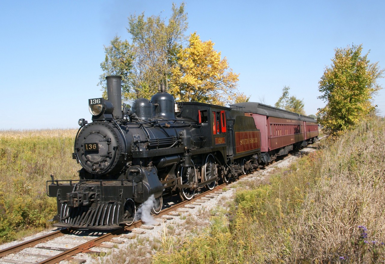 The South Simcoe Railway operates over four miles of former CN trackage between Tottenham and Beeton. Excursions take approximately 50 minutes and passengers ride in 1920 era coaches ... push north and pull south. The star of the show, in attractive livery, is an ex-CP 4-4-0 #136 built in 1883. This starlet was used in the 1970's for the CBC television series The National Dream. This morning's steam excursion was captured amidst fall colours on its return trek as it nears Tottenham Station.