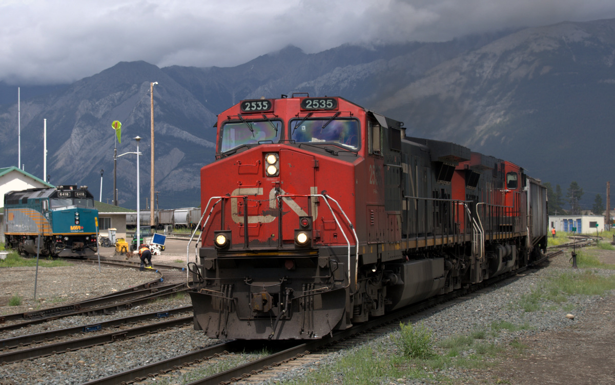 CN2535 Departs after a crew change in Jasper, while VIA crews work on getting VIA 6418 ready shortly after a thunderstorm passes through.