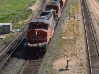 A loaded grain train heads out of Edmonton, headed for the west coast. In the yard to the left of the train can be seen a set of empty Sulphur cars. They are either going to leave by heading NW on the Sangudo Sub or South on the Camrose Sub (Ultimately, using the Brazeau Sub) to the sour gas fields in the foothills of the Rocky Mountains. 