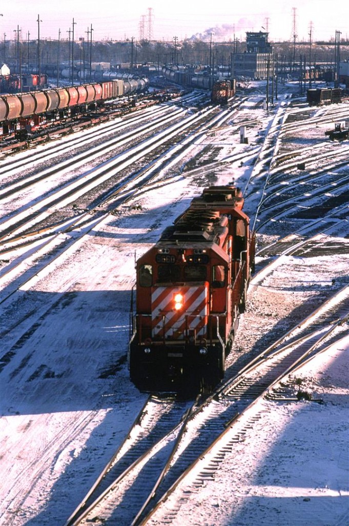An interesting view of Alyth Yard. A couple DS-40's are coming off their train, as a hump set pulls down another string of cars. Note the row of cabooses, and the TOFC/COFC cars, and one looks carefully in the top left, a radio control car in British Colombia Railway may be seen.