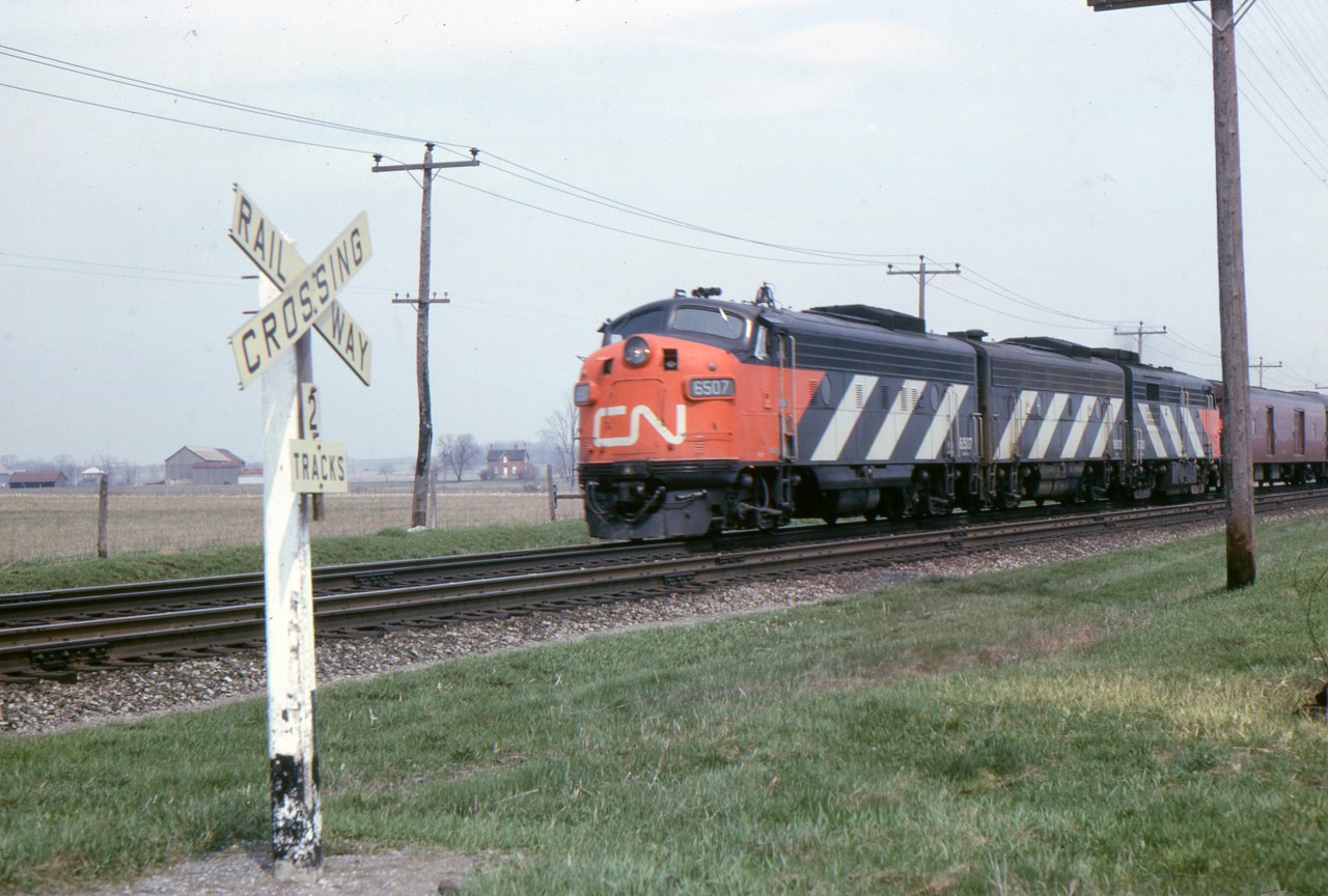 Pool 5 the La Salle is about to cross Lake Road Bowmanville, in this May 1965 photo. A few years earlier Bowmanville was a regular stop for No. 5 but not in 1965. The Pool Agreement will soon end too. The well maintained track and clean right of way are typical of CN in the 1960s. I'm not sure if this was still the Oshawa Sub. or had been changed to Kingston Sub. by 1965.