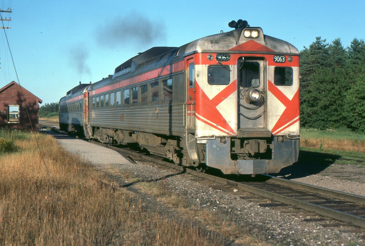 Havelock to Toronto Sunday only train 383 is seen passing Burketon Ontario 40 years ago, on July 25, 1976. This was a popular way to travel from Peterboro to Toronto and a great convenience to people in Havelock and other small communities on the line. VIA maintained it until the infamous cuts of January 1990. Proposals to restore the service failed and are more unlikely now with the completion of highway 407 coming soon. In the photo, the station has been replaced with a shelter and the train is accelerating as there are no passengers at the flag stop.