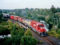 CP 5549, HLCX 3066 and CP 5694 make up the power on this days' Winnipeg-Toronto train #474 as it is about to duck under Hwy 69 on its way into Britt. The HLCX was a former UP, same number. The Still River looks rather peaceful in this photo. Dry summer, I guess.