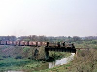 A CN freight lead by a pair of GMD SW1200RS units crosses a small bridge over a branch of the Thames River, at Mitchell on the Goderich Sub in April 1969. This of course is GEXR territory today.