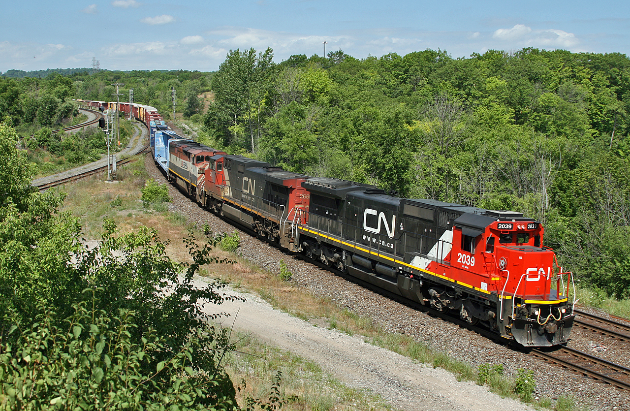 CN 2039, CN 2660 and BCOL 4619 work hard to hold back the 167 cars that make up M 39491 12 as they reach the bottom of the Copetown hill.  Since hitting the double track at Komoka, 394 had been struggling to keep this 10,200 foot train ahead of 148 who was operating on the north track, however at Brantford 148 got the upperhand and overtook 394.  148 had passed through Bayview 8 minutes ago with the CN 2152, CN 5689 handling 121 cars.  I guess I should have gone to Brantford!