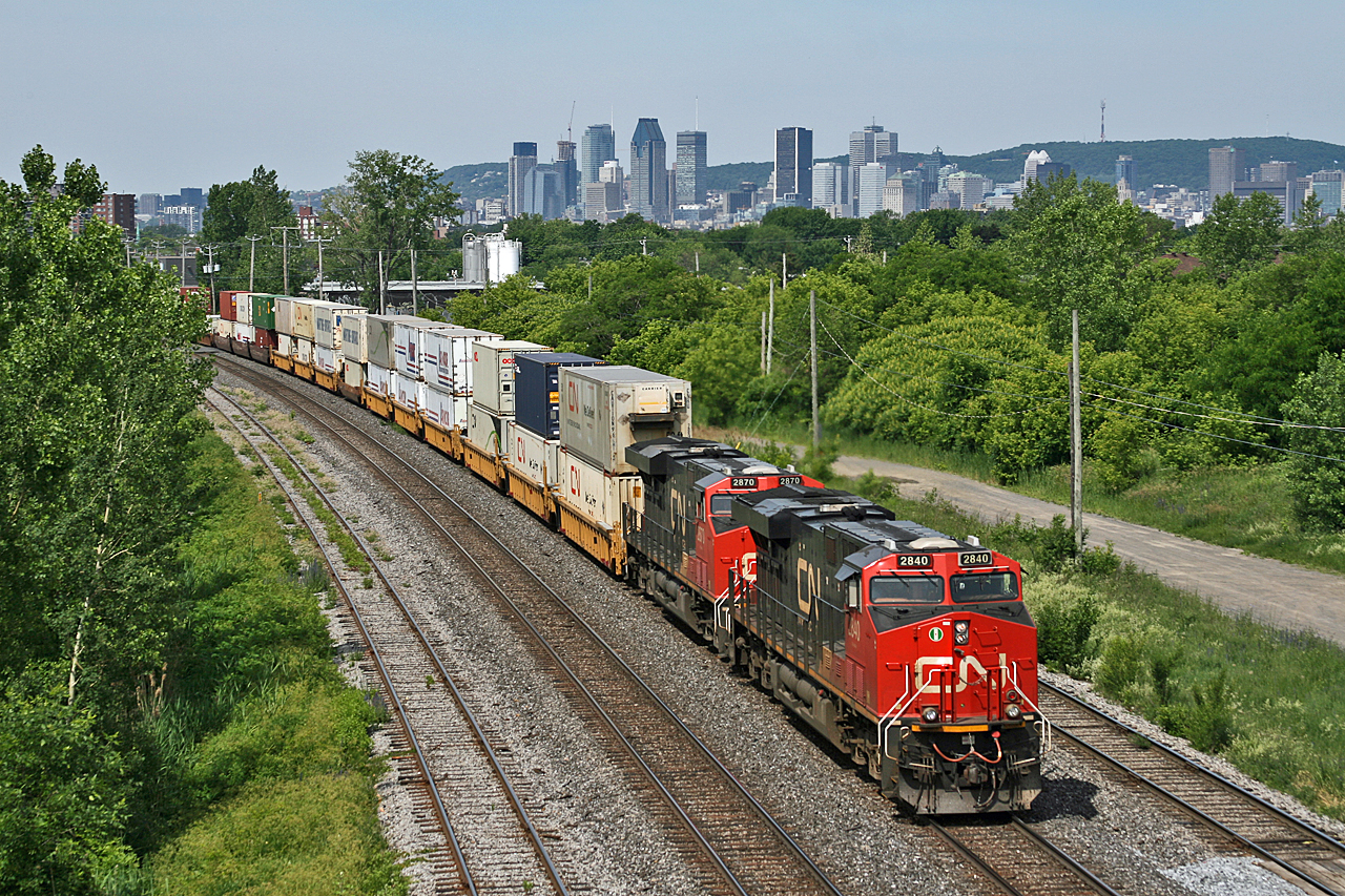 With the City of Montreal's skyline in the distance, hot shot Q 12031 18 pulls their 205 car train off the Victoria Bridge, enroute to Joffre and eventually Halifax, Nova Scotia.  Power today was CN 2840, CN 2870 and mid-train DP CN 2817, with over 13,000ft of traffic for the east coast.