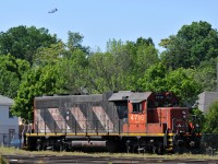 CN 4710 spends the weekend shut down in the locomotive track at Brantford, as a Canadian Forces C-130 circles overhead on approach to the airport