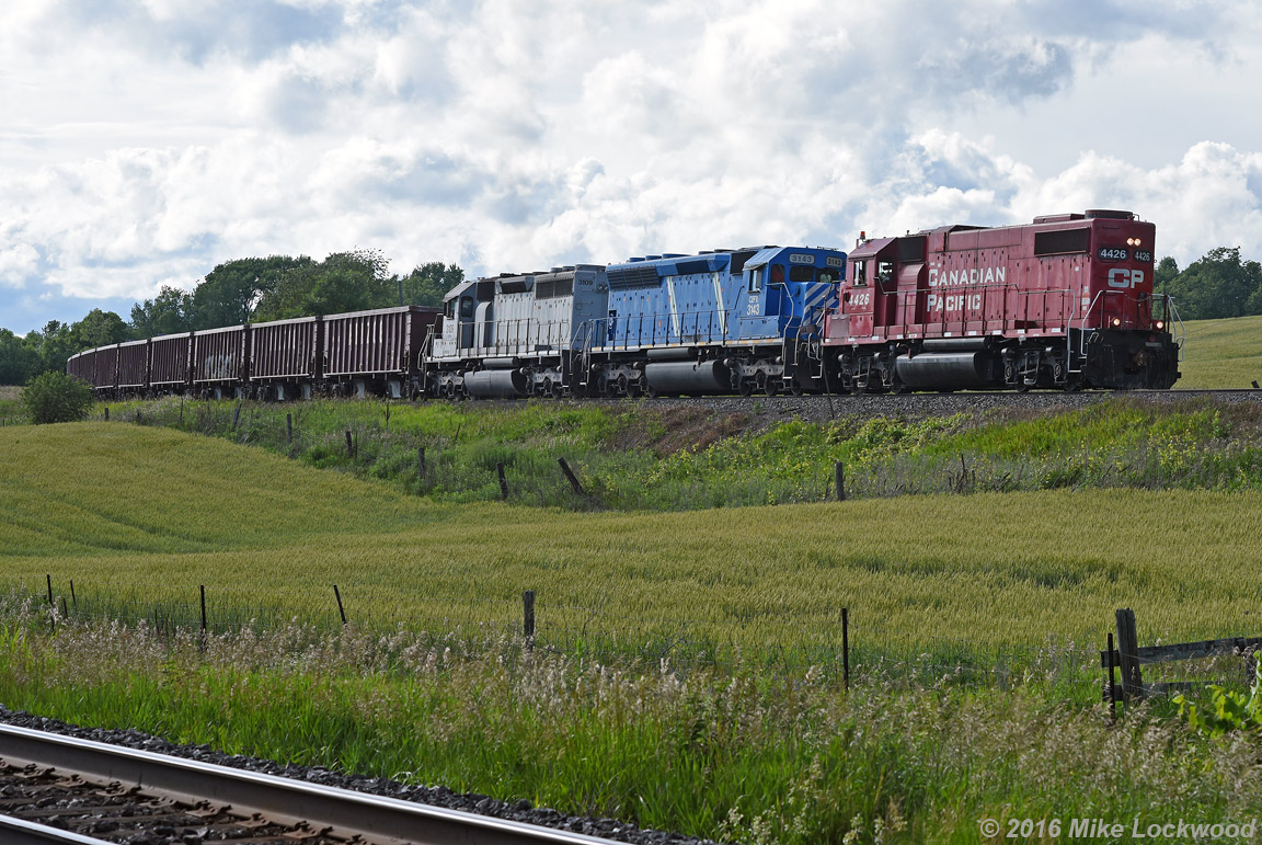 Nearing the end of it's run dumping ballast between Lovekin and Port Hope, CP 4426, CEFX 3143, and CEFX 3109 round the curve a few hundred feet from the west home signal at Port Hope. Problems with the 3143 necessitated the addition of 4426 at Toronto Yard, which wasn't all bad given the not so common long hood forward orientation of the remote control equipped geep leading on the main. The return trip also saw the 4426 leading back to Toronto, the crew having run around the SD's in the back track at Spicer, where they ended their eastbound movement. 1747hrs.