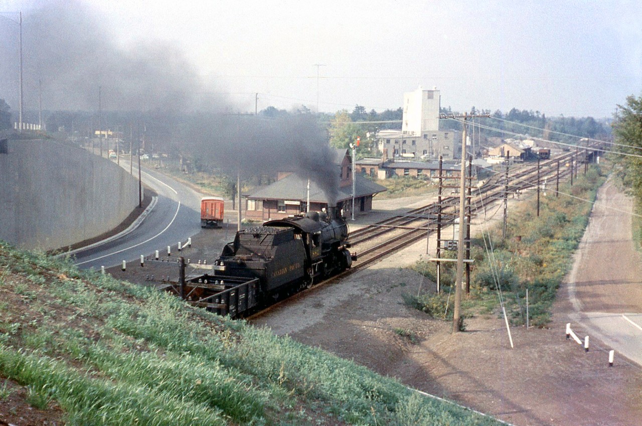 As a follow-up from the previous image of the steam-powered westbound at Cooksville, here's a general overview of the Canadian Pacific's Cooksville Station area looking northwest from the top of the Highway 5 / Dundas Street East overpass in 1957. CPR D10 882 has just passed under the overpass and is heading west on the Galt Sub past the old wooden Cooksville Station (note the old red CP Express truck parked outside). In the background is the S.H. Dellow Block and Builders supply plant, a longtime local maker of concrete blocks (with a siding for rail service).

More Cooksville: CPR doubleheader passing the Cooksville Brick plant further down the line: http://www.railpictures.ca/?attachment_id=14123