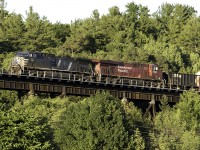 As the days light is almost gone, CEFX 1055 west leaps out of the trees onto the famous trestle over the Seguin River.