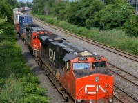 <b>DC power, elephant style.</b> CN 120 mostly gets ES44AC's and ET44AC's as power these days, but here DC power units CN 2307 & CN 2039 (arranged elephant style) lead CN 120, with a third DC power unit mid-train (CN 2660) not too long after the train left Taschereau Yard in Montreal.