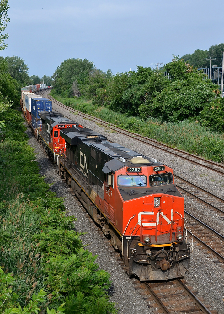 DC power, elephant style. CN 120 mostly gets ES44AC's and ET44AC's as power these days, but here DC power units CN 2307 & CN 2039 (arranged elephant style) lead CN 120, with a third DC power unit mid-train (CN 2660) not too long after the train left Taschereau Yard in Montreal.