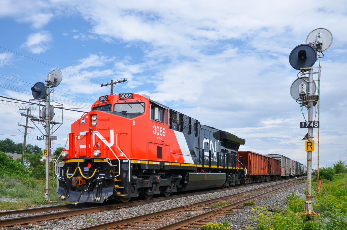 Factory fresh. Brand new ET44AC CN 3069 is only a few weeks out of the factory as it leads CN 377 past some nice searchlight signals on CN's Kingston Sub in Beaconsfield. Operating mid-train is ET44AC CN 3055, only a few months older than the leader.