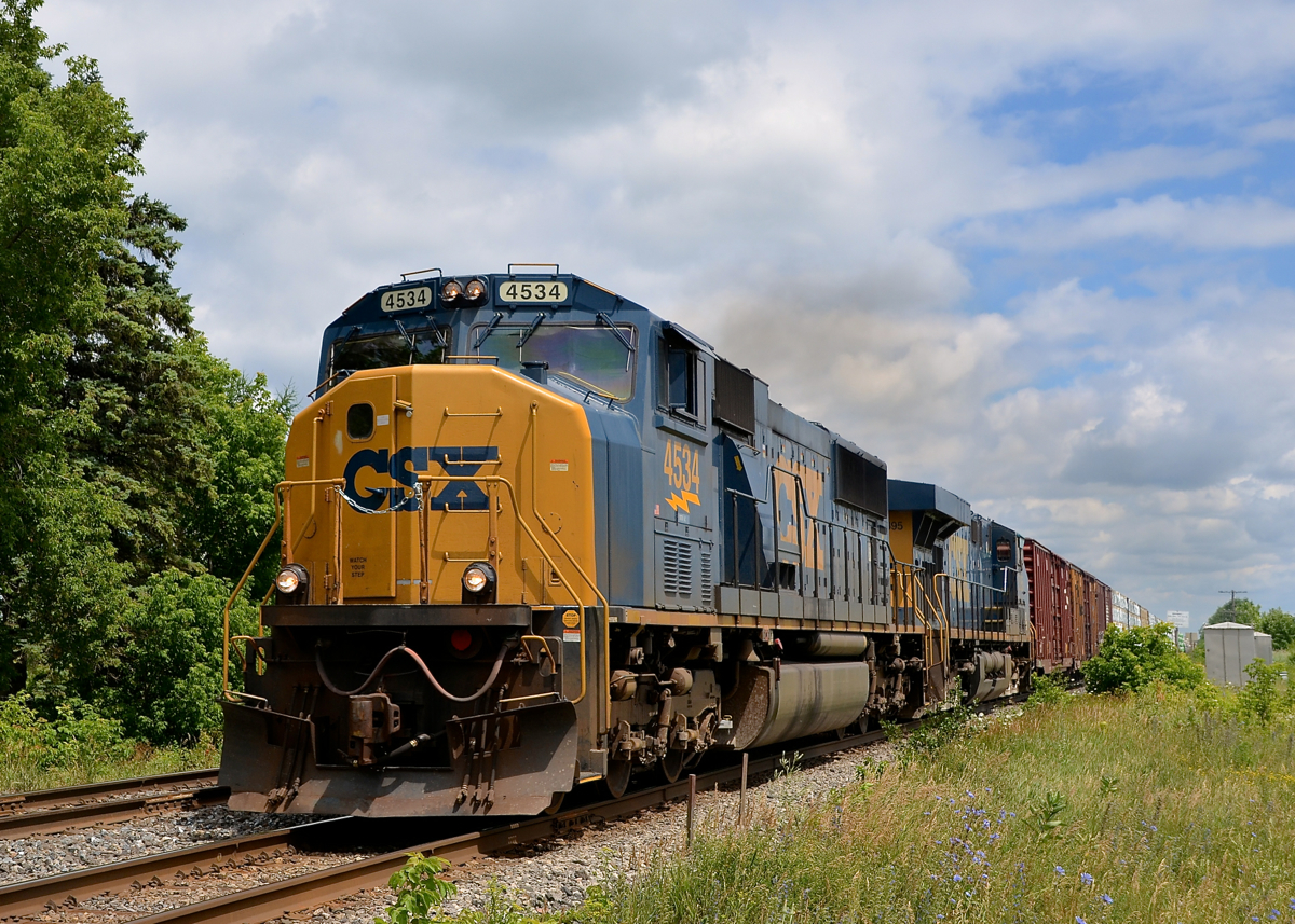 SD70MAC on the Kingston Sub. SD70MAC CSXT 4534 leads a 70-car CN 327 westwards on the south track of the Kingston Sub. Up ahead in Coteau the train will leave the Kingston sub for the Valleyfield sub, and eventually the U.S. Trailing is CSXT 5395.