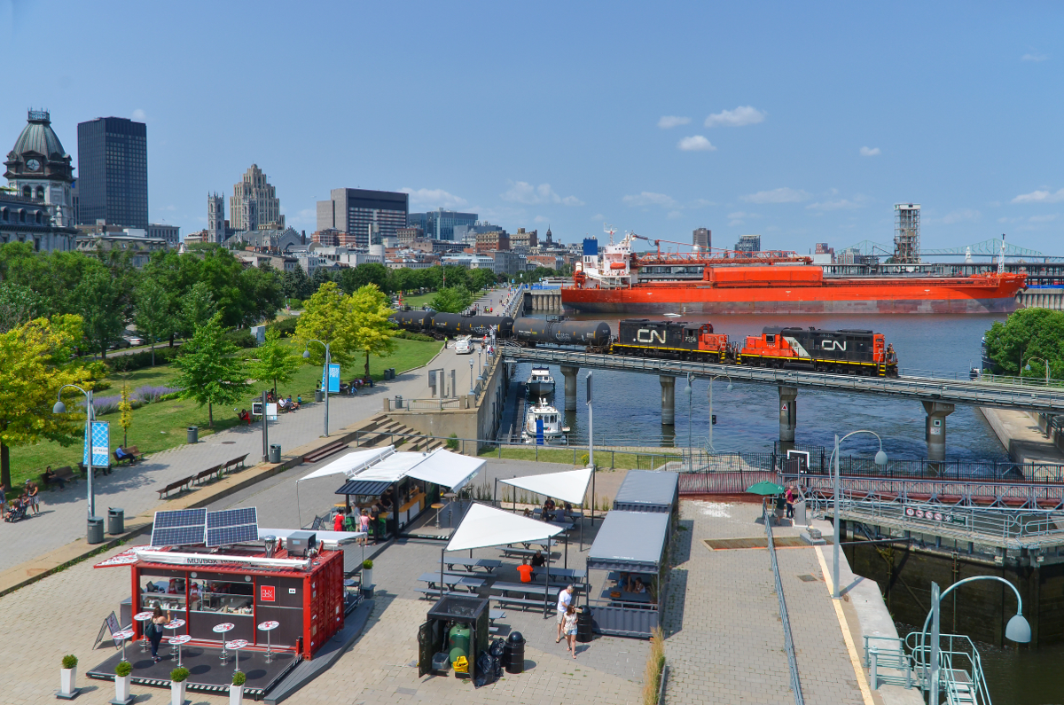 Nose to nose GP9's. GP9's CN 7075 & CN 7256 are lashed up nose to nose as they cross the Lachine Canal with a short train out of the Port of Montreal on a sunny afternoon.