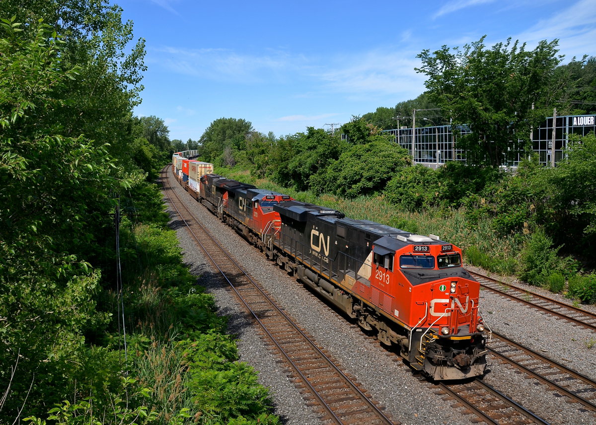 A late CN 120 has CN 2913, CN 2173 & CN 2337 at head end, with CN 3022 operating mid-train as it heads east on the Montreal sub.
